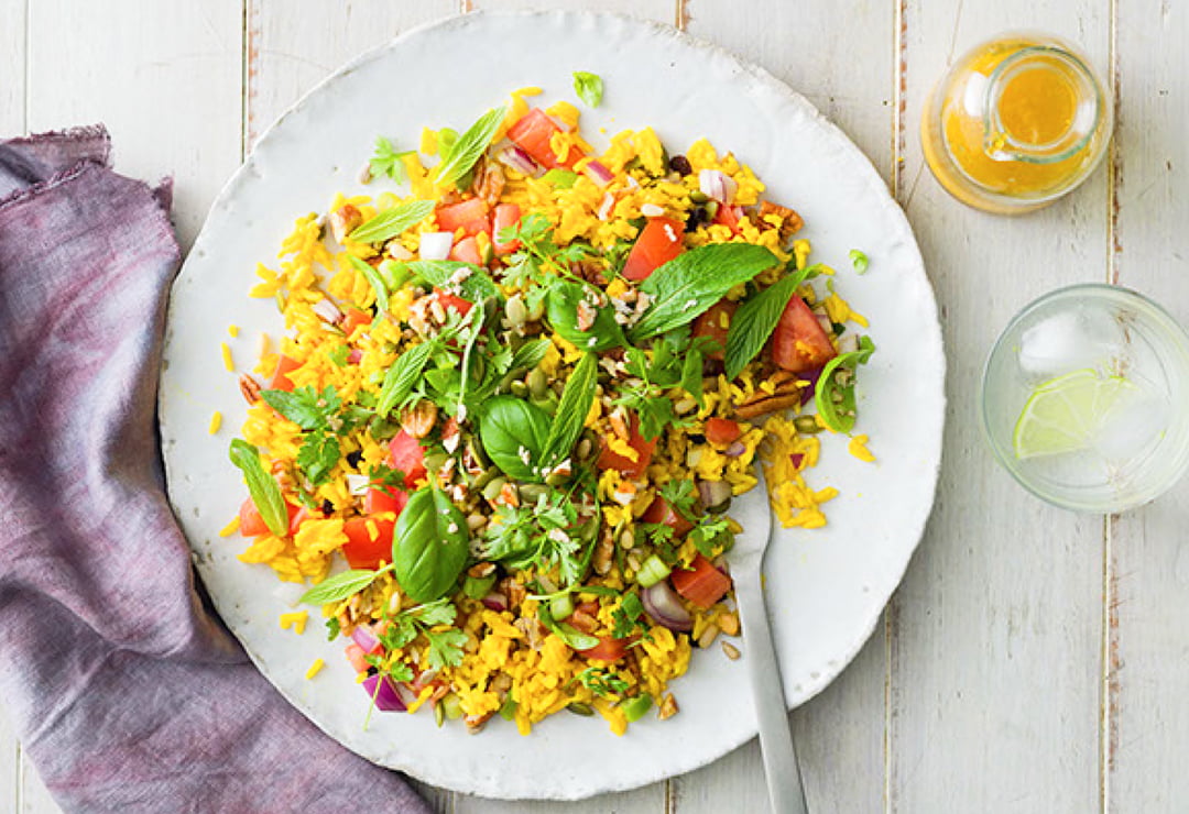 Yellow rice salad with seeds, nuts and green herbs